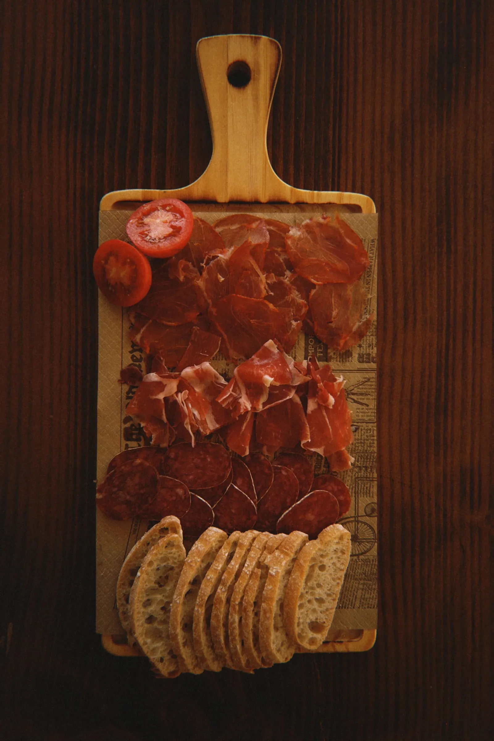 Tabla de jamón ibérico con tomate y pan.
