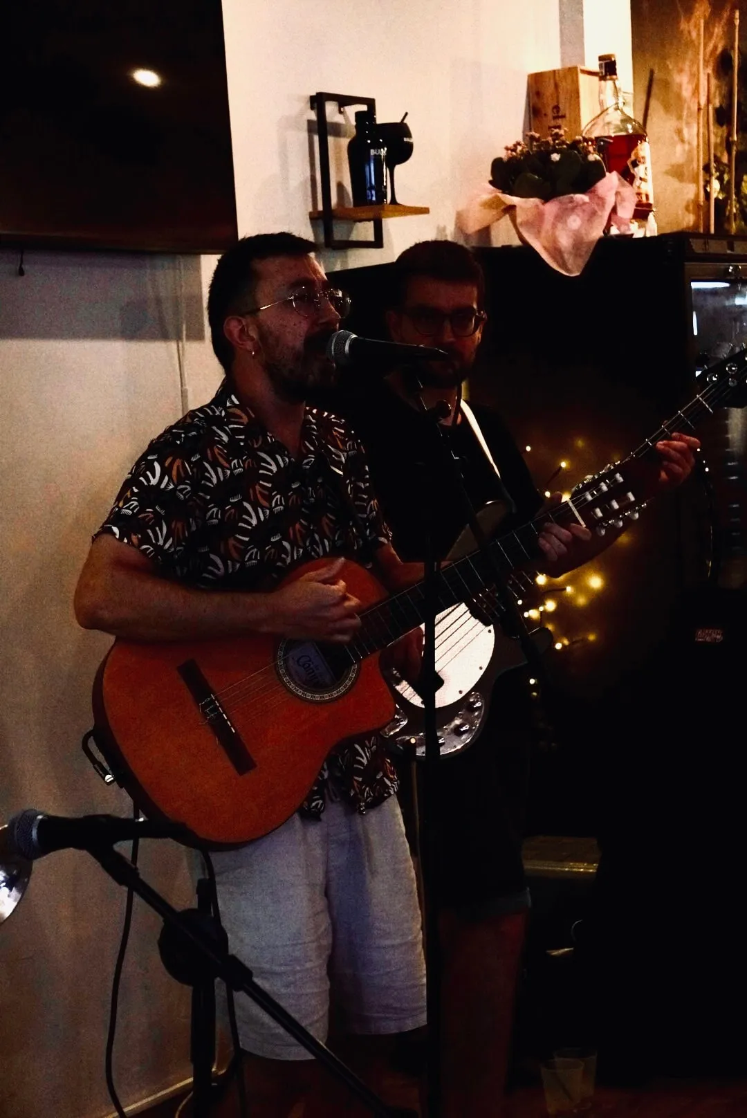 Dos músicos con guitarras en una tarde de música en directo.